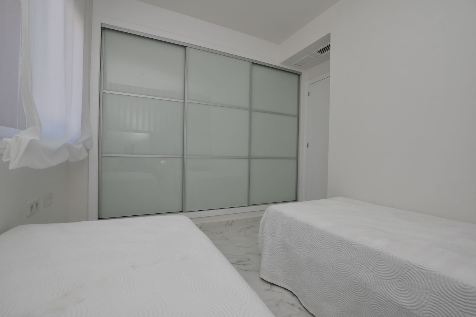 Stylish twin bedroom with built in wardrobe in new build apartment in San Miguel de Salinas